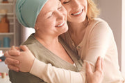 A joyful embrace between two women in a warm kitchen setting, symbolizing the care, wellness, and support promoted by CBD Malta for a healthier lifestyle.