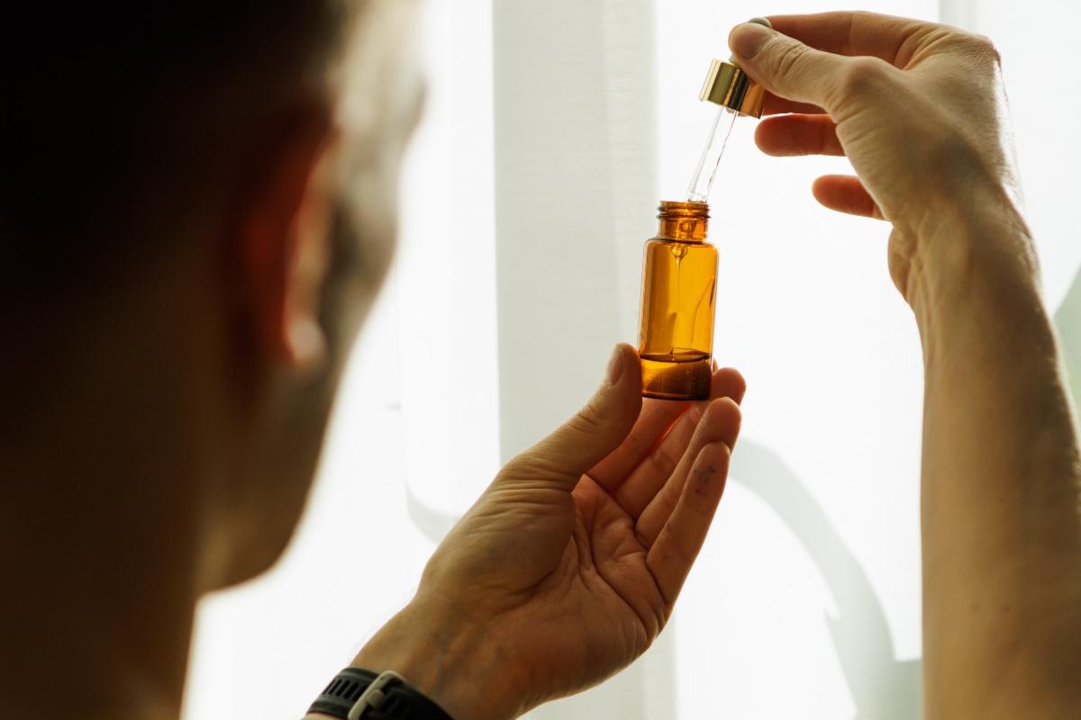 Person holding a premium CBD tincture bottle in natural light, representing the high-quality, THC-free CBD oils available at CBD Malta. Perfect for promoting relaxation, wellness, and vitality.