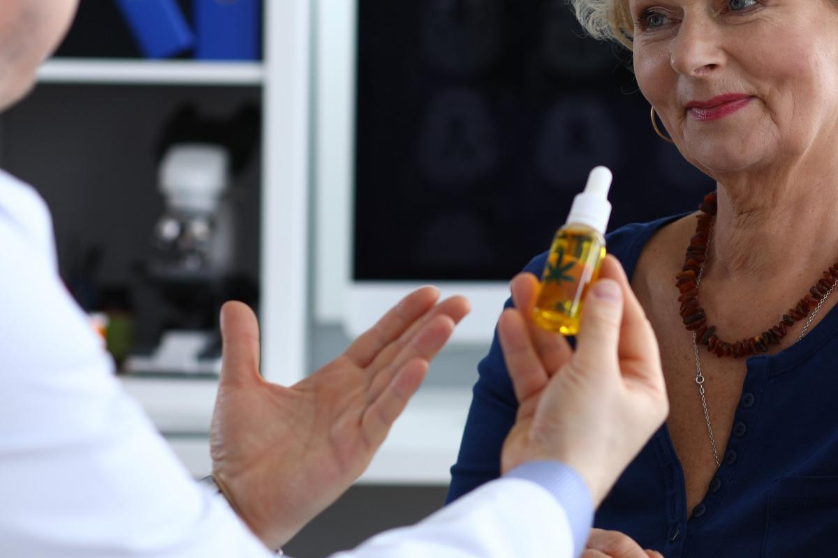 Doctor holding a CBD oil bottle during a consultation with a patient, emphasizing the trusted and professional approach to wellness with CBD products available at CBD Malta.