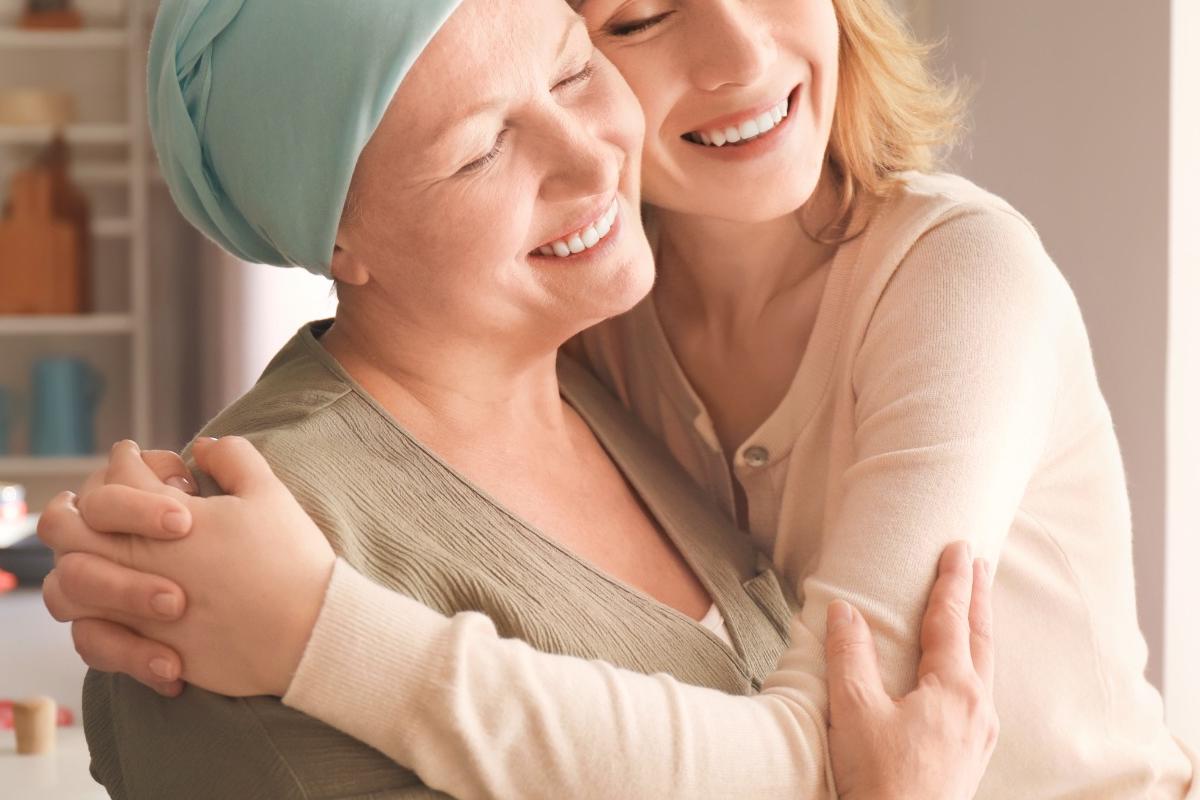A joyful embrace between two women in a warm kitchen setting, symbolizing the care, wellness, and support promoted by CBD Malta for a healthier lifestyle.