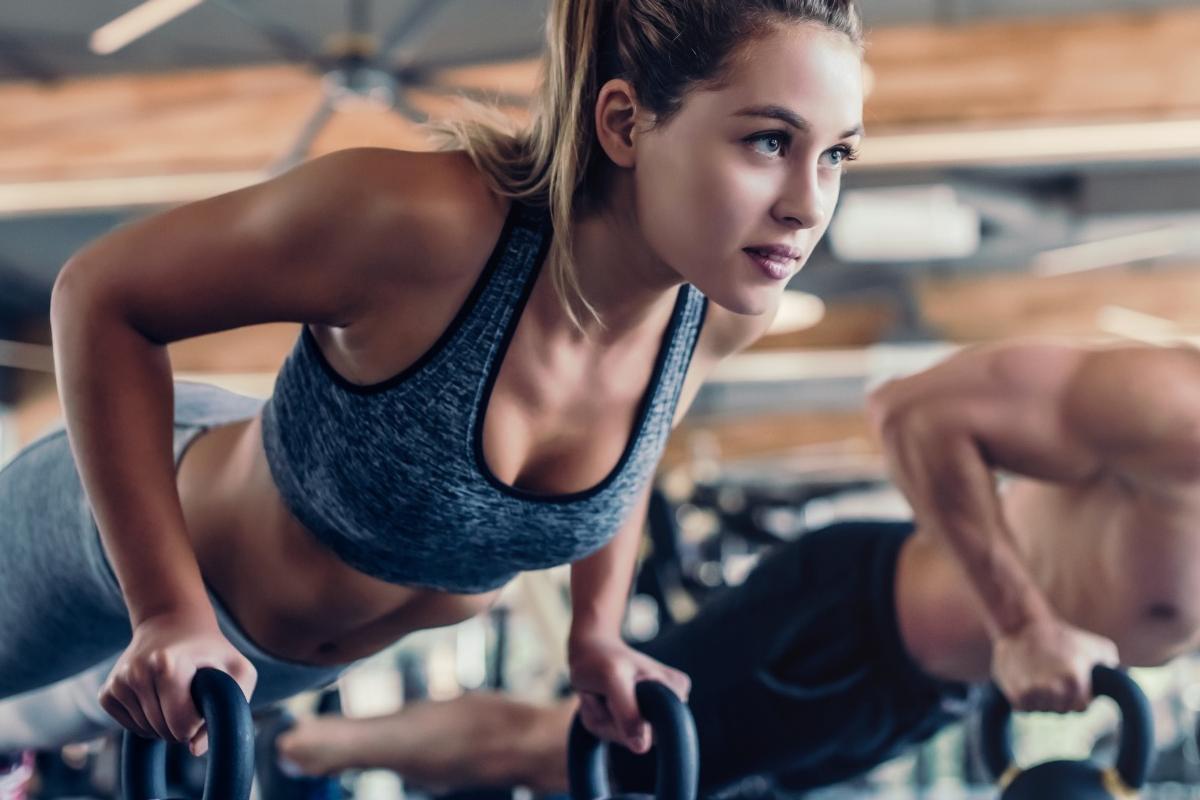Focused fitness training with kettlebell exercises in a modern gym, highlighting health and wellness in Malta. Perfect for CBD enthusiasts seeking an active lifestyle.
